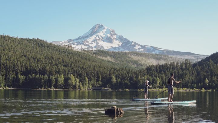 Couple stand up paddle boarding on Laurance Lake in Parkdale, Oregon